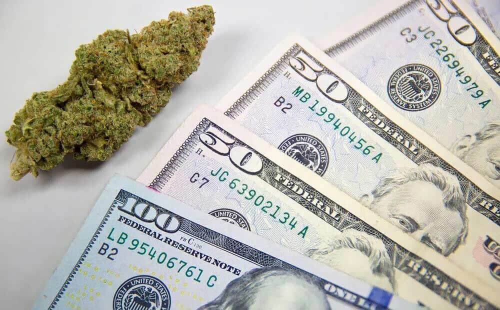 A cannabis nug next to 4 $50 bills.
